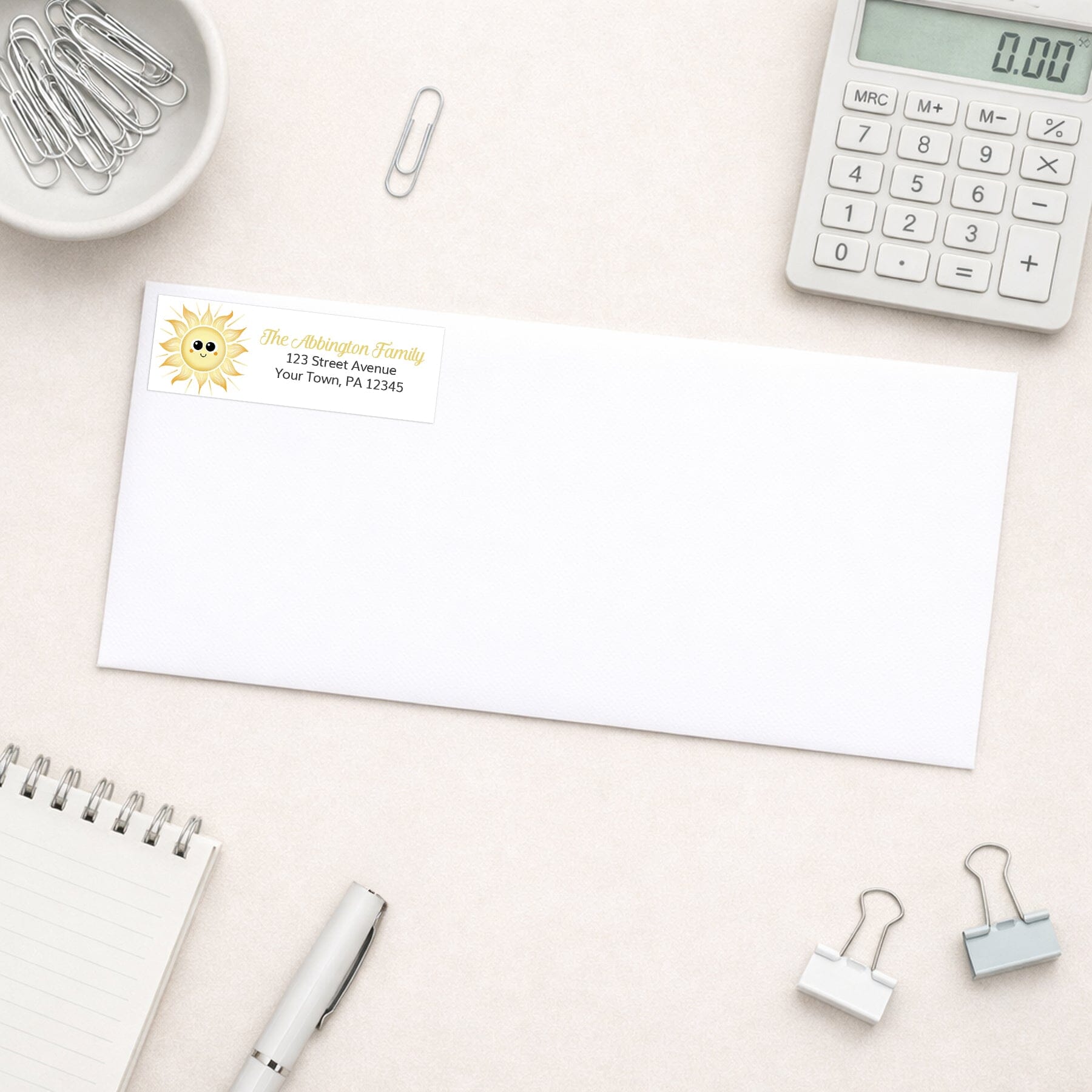 White envelope shown with the personalized Happy Sun Address Label on a desk with office supplies