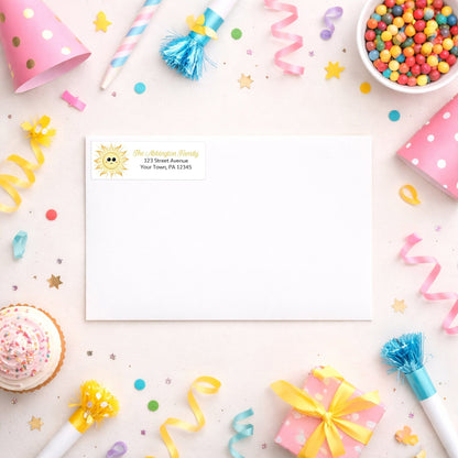 White envelope shown with the personalized Happy Sun Address Label on a desk with party supplies