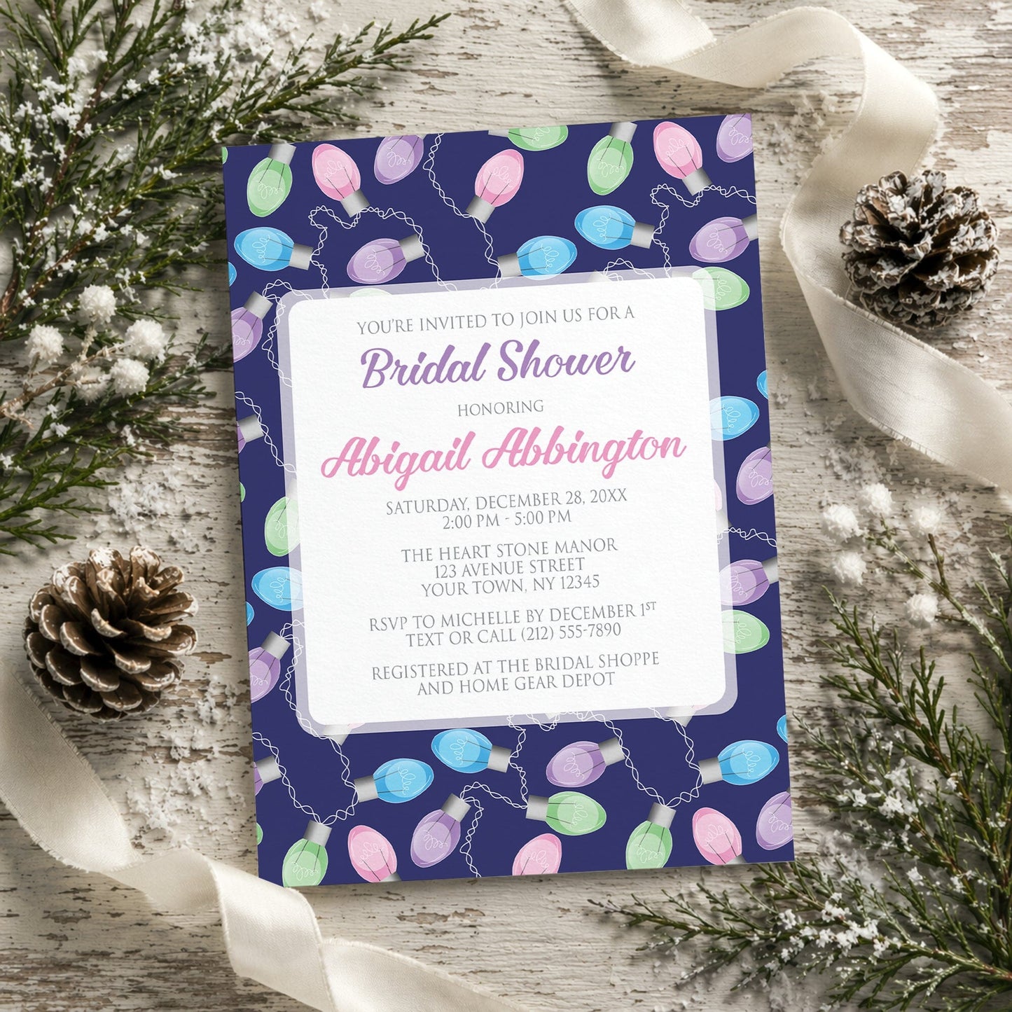 Holiday Lights Pattern Bridal Shower Invitation shown on a rustic surface with winter greenery, pine cones, and ribbons.
