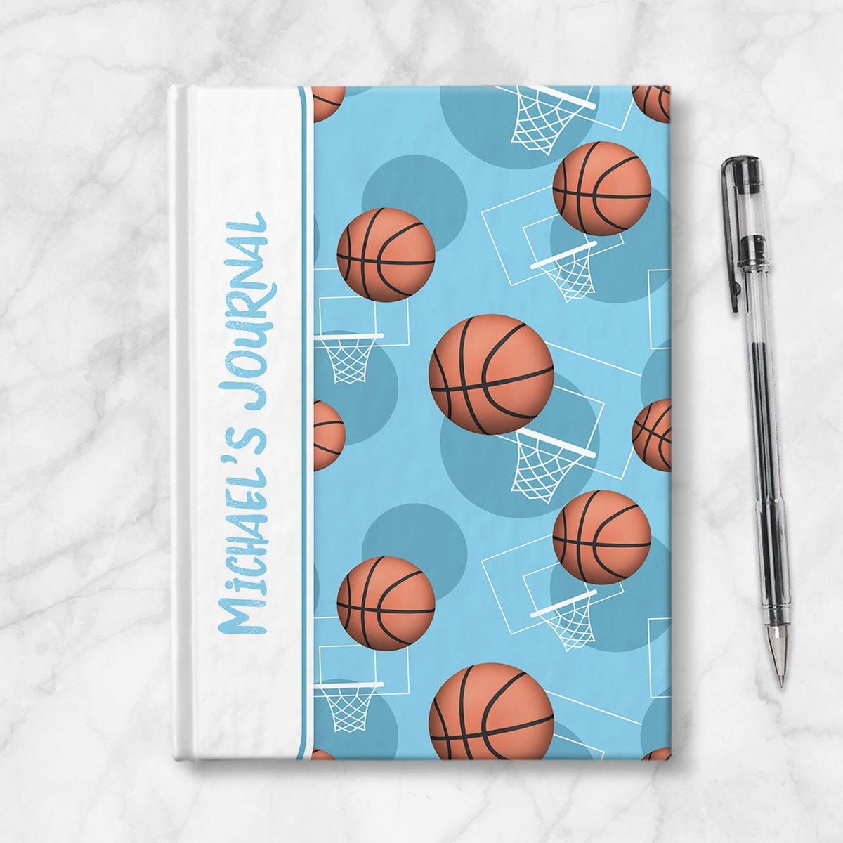 Personalized Light Blue Basketball Journal at Artistically Invited. Image shows the book on a countertop next to a pen.