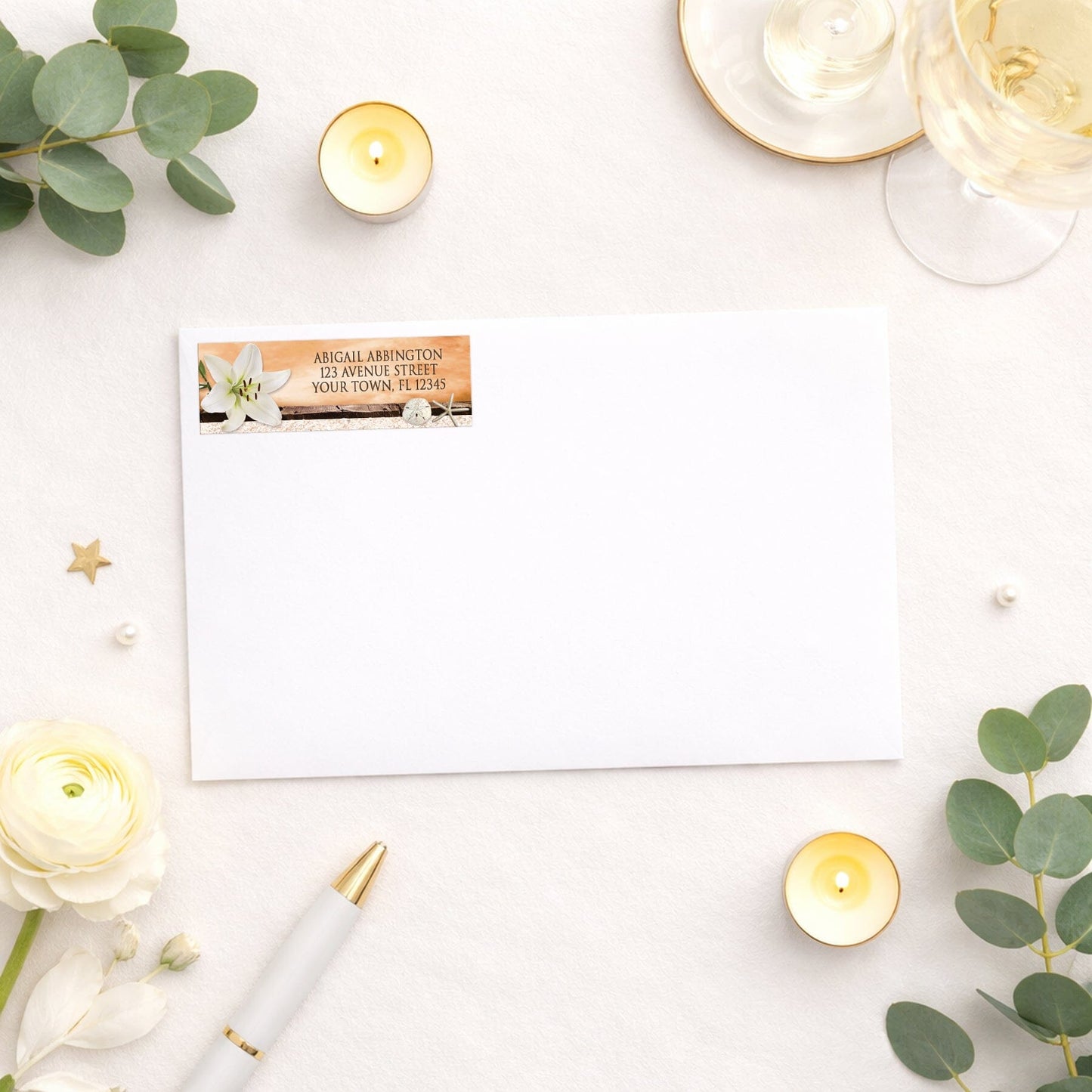 Lily Seashells and Sand Autumn Beach Address Label shown on a white envelope with wedding and shower supplies