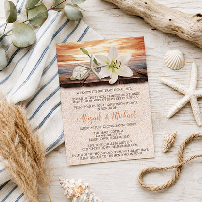 Lily Seashells and Sand Autumn Beach Honeymoon Shower Invitation shown on a light wooden surface with seashells and coastal decor.