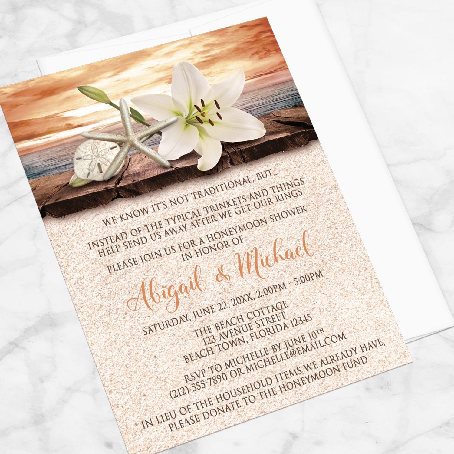Lily Seashells and Sand Autumn Beach Honeymoon Shower Invitation shown at an angle on a marble surface with a white envelope.