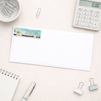 Lily Seashells and Sand Beach Address Label shown on a white envelope with office supplies