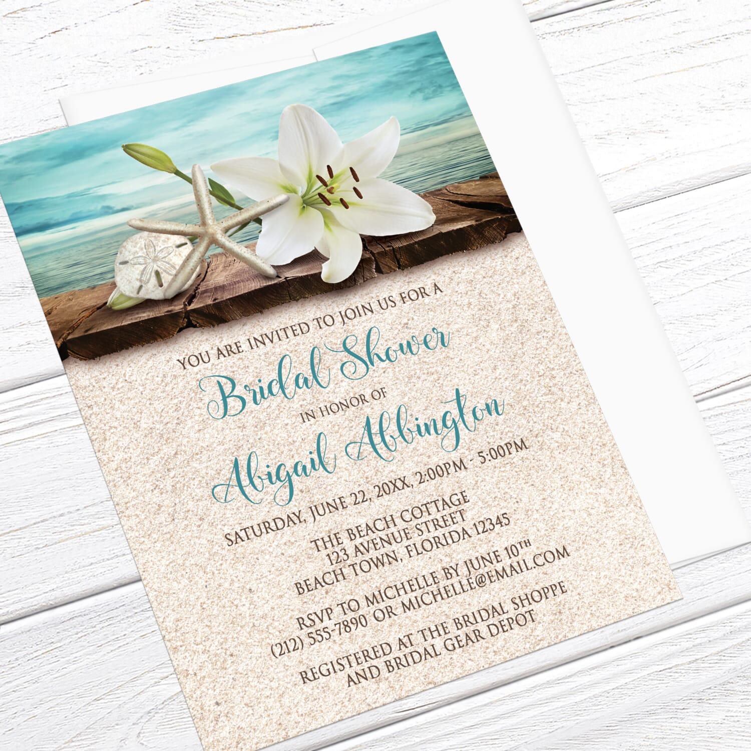 Beach-themed bridal shower invitation with floral and shell design on a wooden surface.