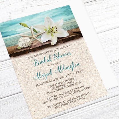 Beach-themed bridal shower invitation with floral and shell design on a wooden surface.