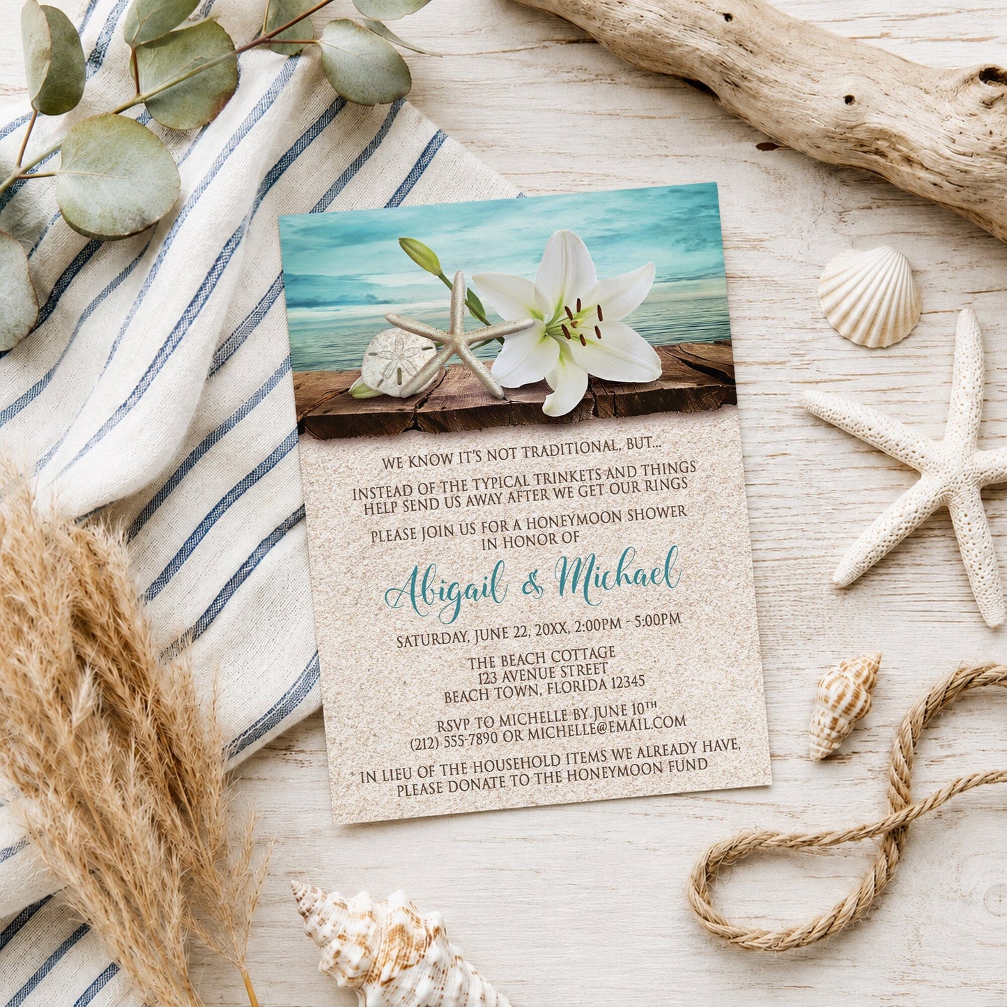 Lily Seashells and Sand Beach Honeymoon Shower Invitation shown on a light wooden surface with coastal decor.