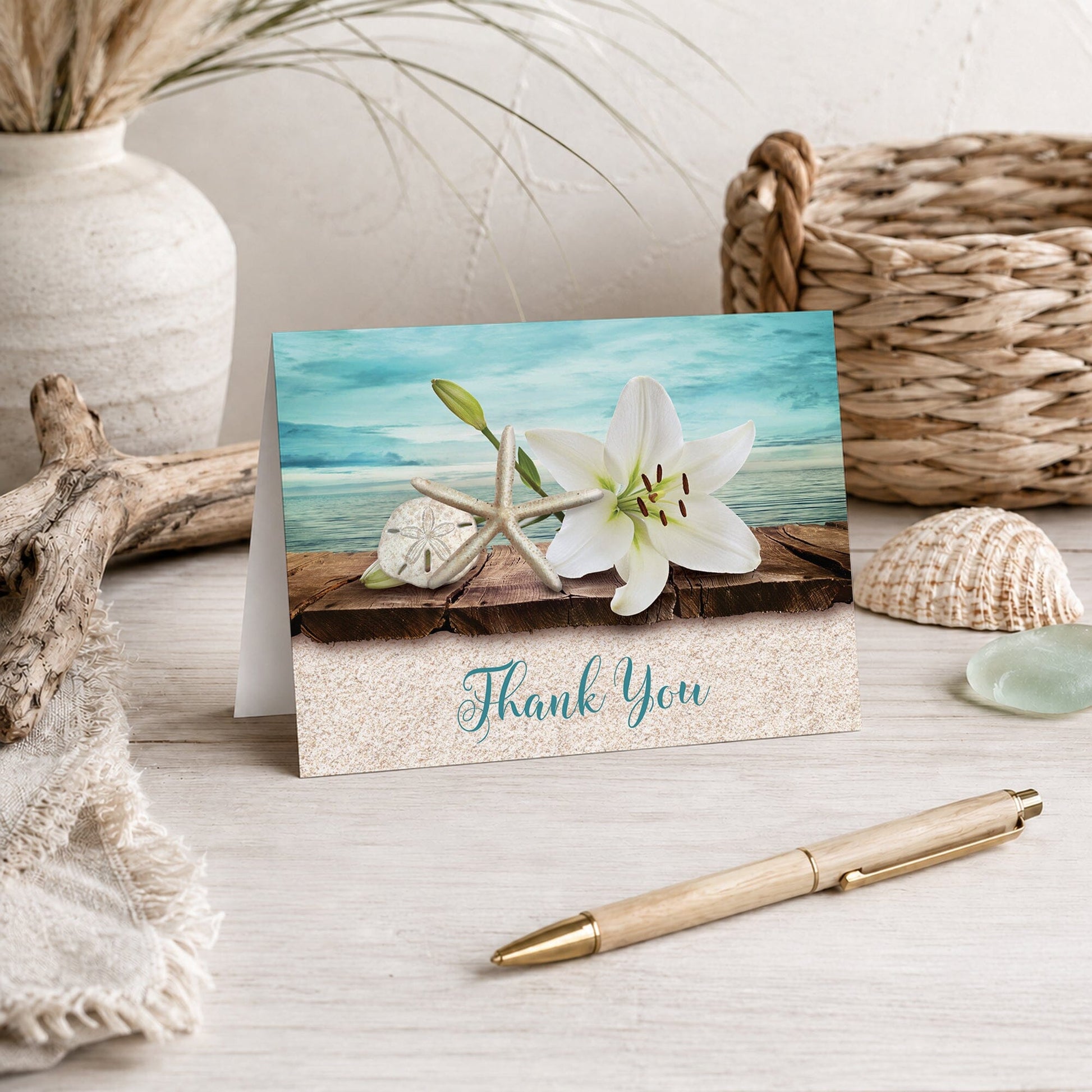 Lily Seashells and Sand Beach Thank You Card shown on a tabletop with a pen, vase, and beach house decor.
