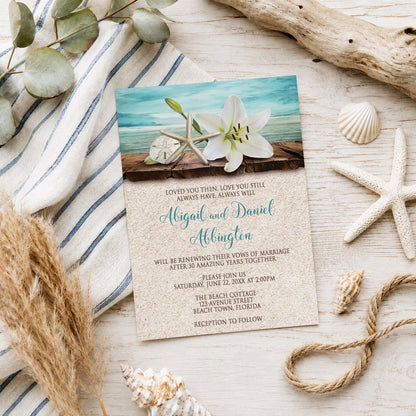 Lily Seashells and Sand Beach Vow Renewal Invitation on a light wooden surface with seashells and coastal decor.