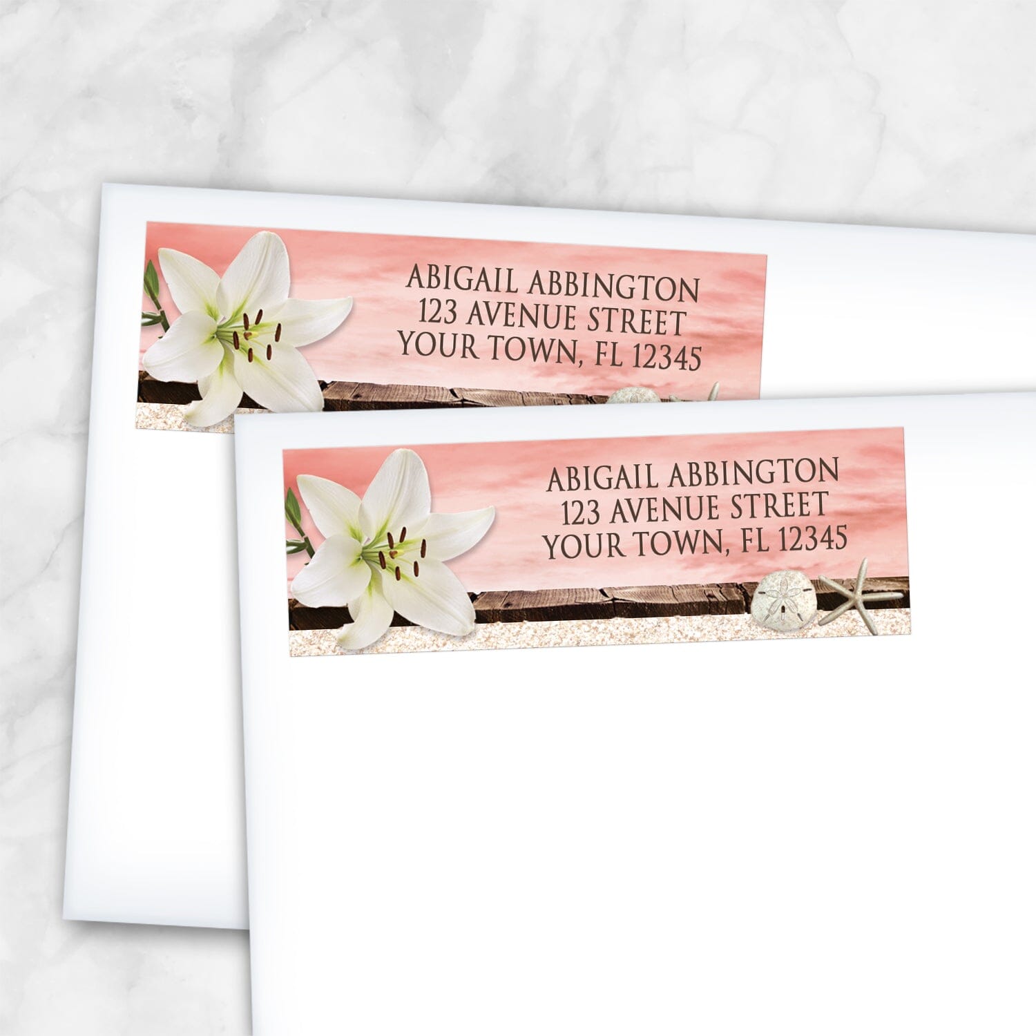 2 Lily Seashells and Sand Coral Beach Address Labels shown on white envelopes on a marble surface