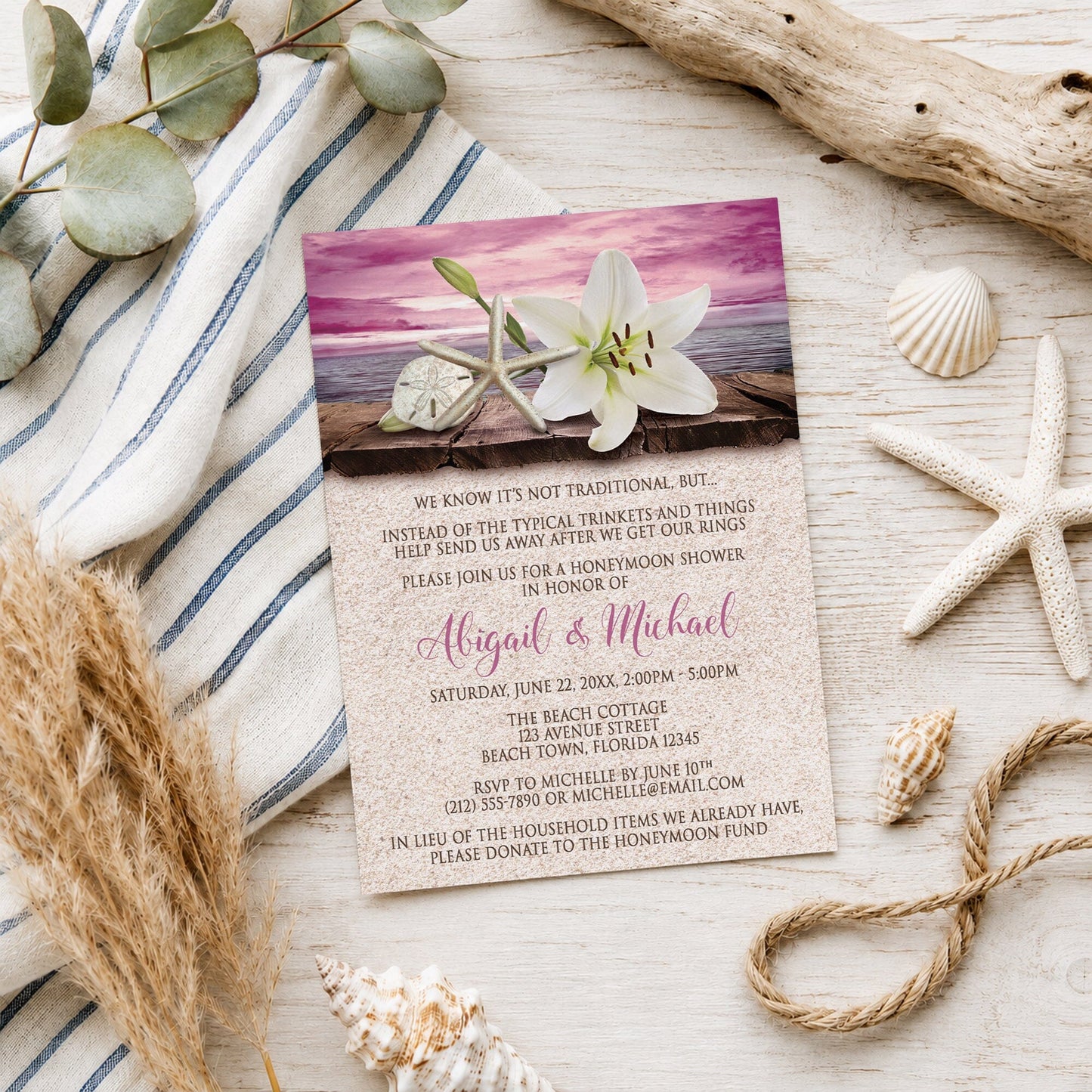 Lily Seashells and Sand Magenta Beach Honeymoon Shower Invitation shown on a wooden surface with seashells and beach decor.