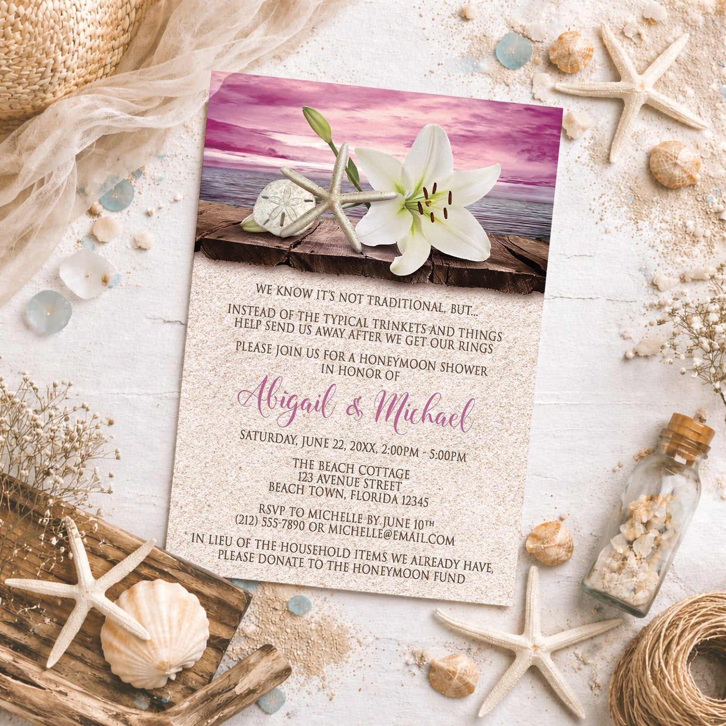 Lily Seashells and Sand Magenta Beach Honeymoon Shower Invitation shown on a light surface with seashells, drift wood, and beach decor.