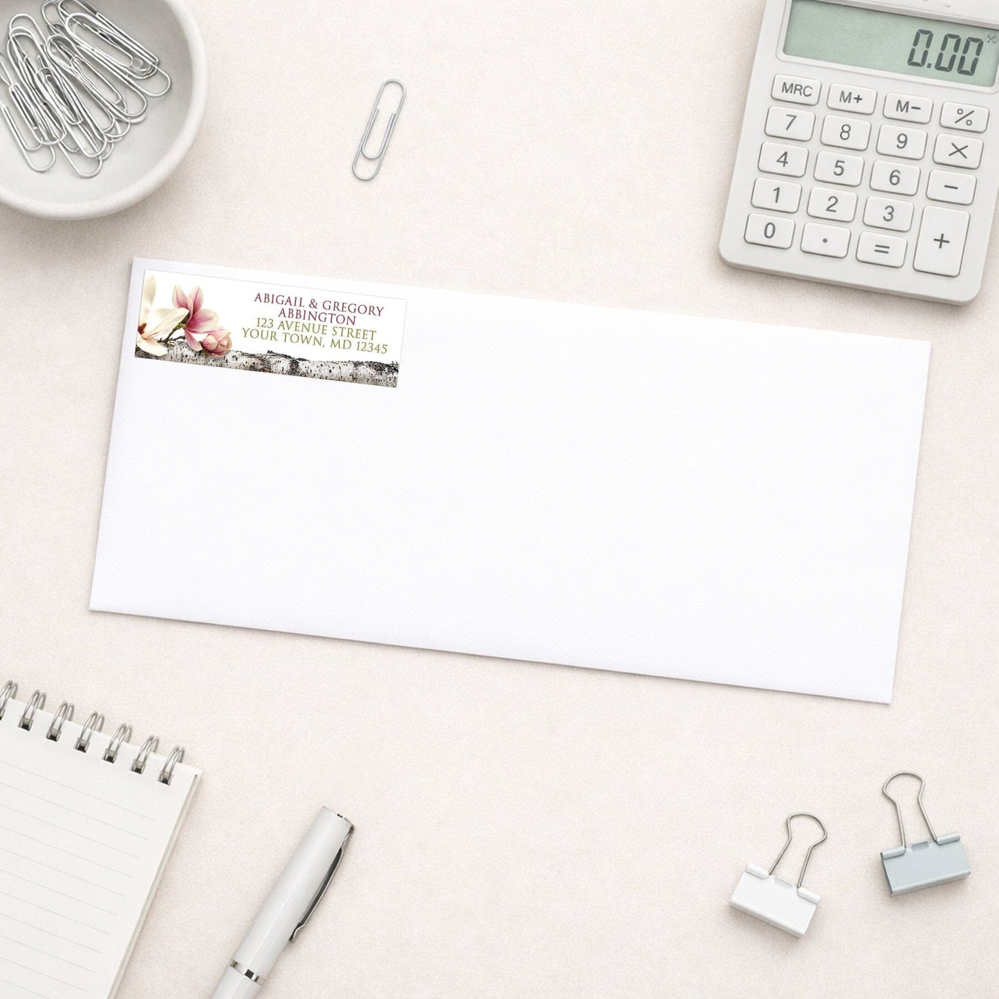 Magnolia Birch Light Floral Address Label shown on a white envelope with everyday office supplies