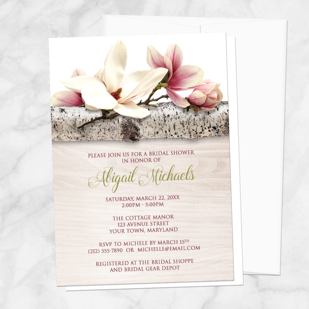 Bridal Shower invitation with a light magnolia design, with a white envelope, on a marble tabletop