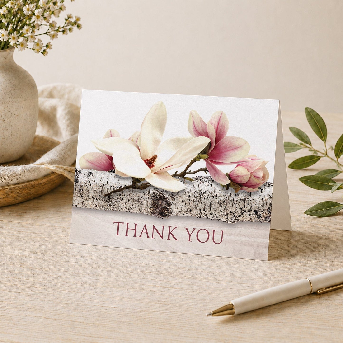 Magnolia Birch Light Wood Floral Thank You Card shown on a tabletop with a vase, plants, and a pen.
