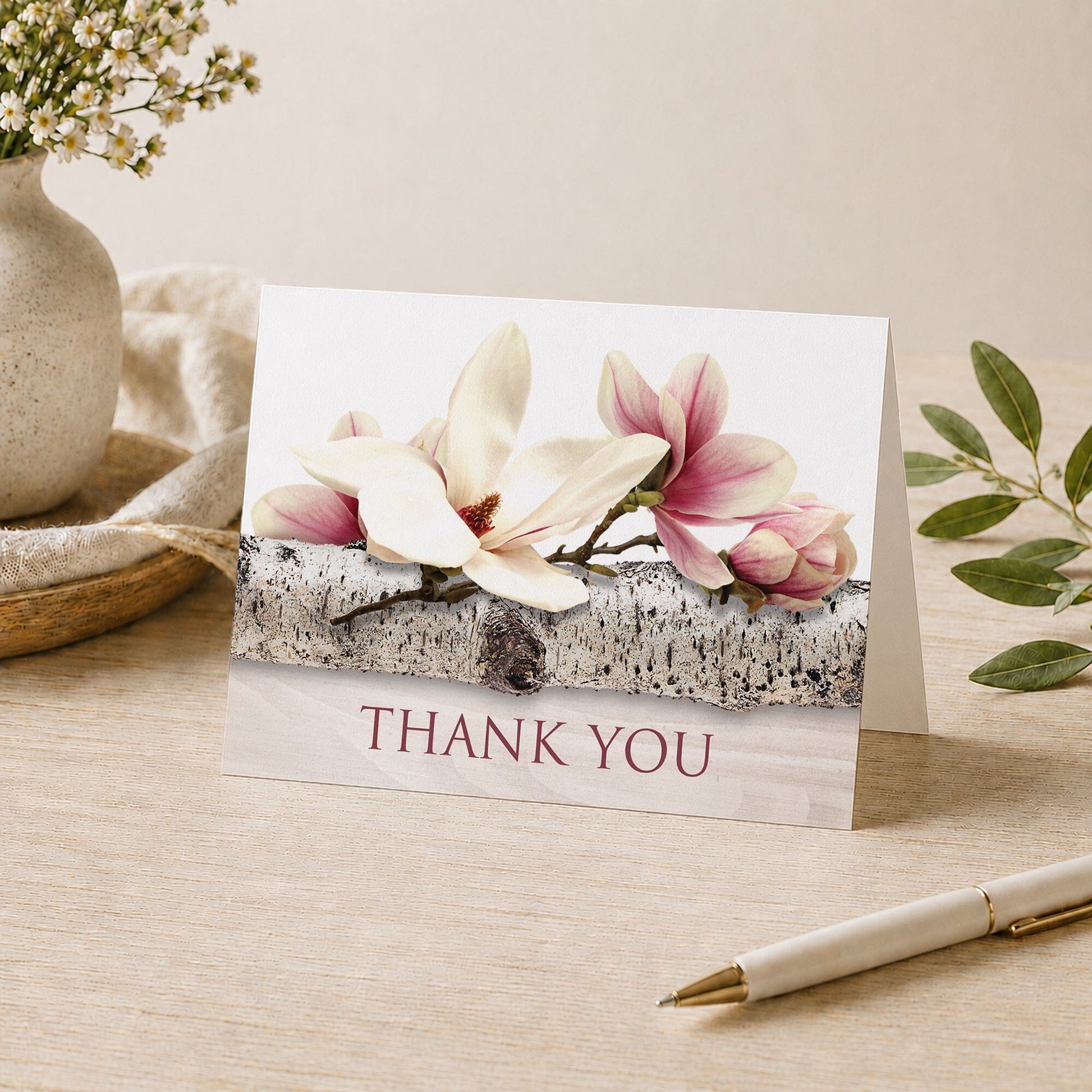 Magnolia Birch Light Wood Floral Thank You Card shown on a tabletop with a vase, plants, and a pen.