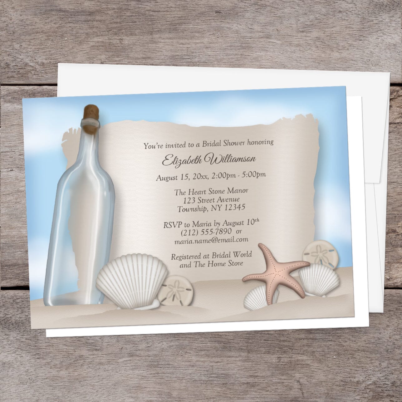 Seashell-themed bridal shower invitation with an illustrated bottle and sand, shown with a white envelope on a wooden background