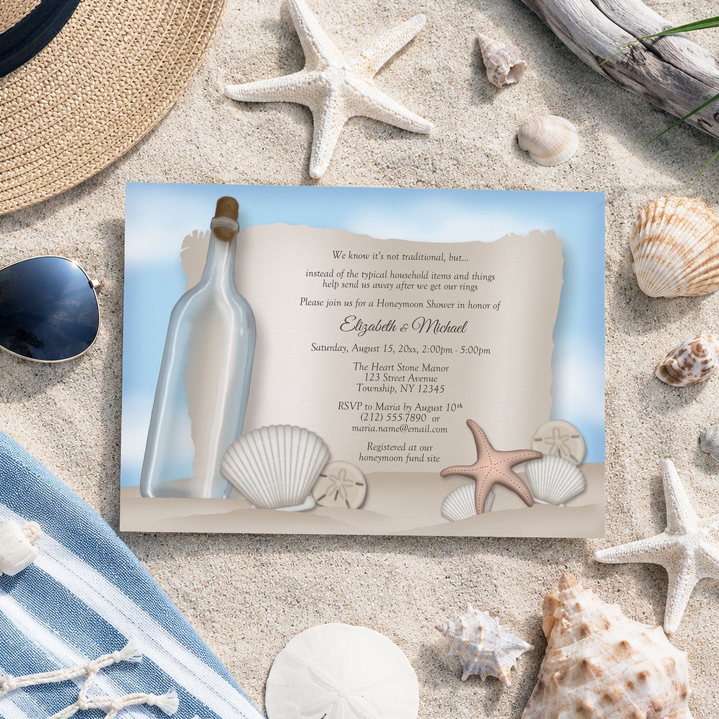 Message from a Bottle Beach Honeymoon Shower Invitation shown on sand with starfish, shells, and a hat.