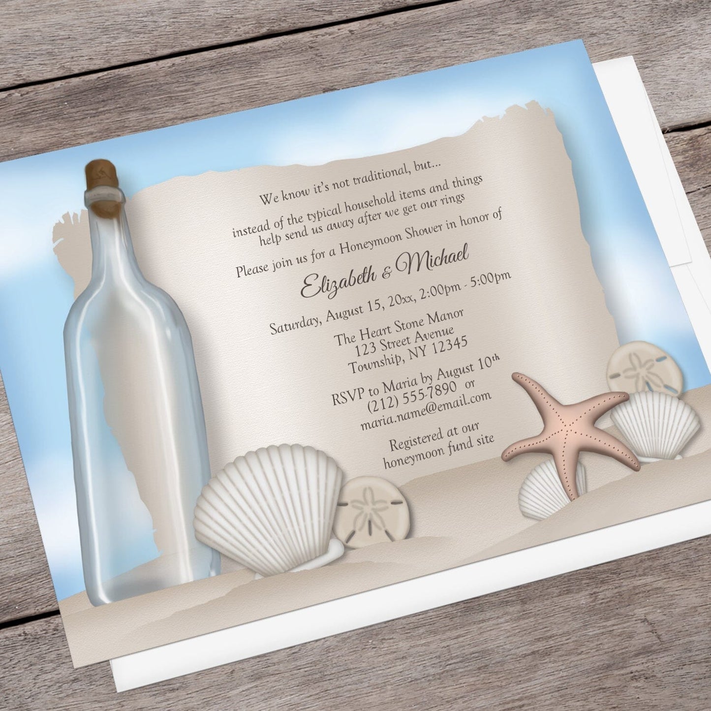 Message from a Bottle Beach Honeymoon Shower Invitation shown at an angle on a brown wood surface with a white envelope.