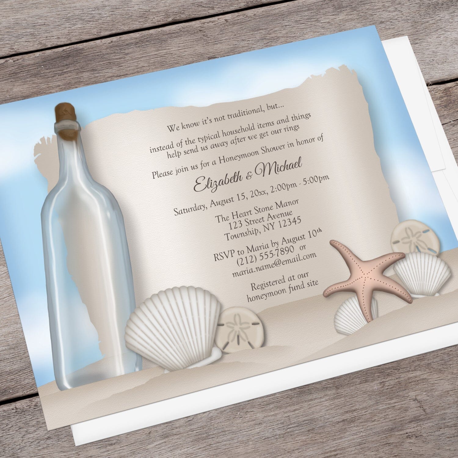 Message from a Bottle Beach Honeymoon Shower Invitation shown at an angle on a brown wood surface with a white envelope.