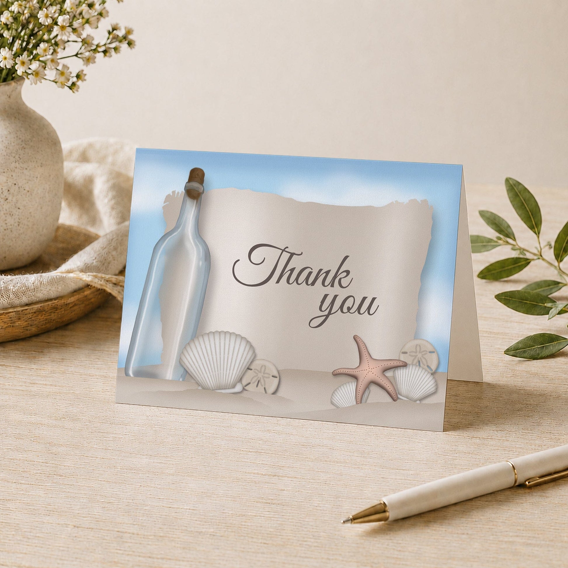 Message from a Bottle Beach Thank You Card shown on a tabletop with a vase, plants, and a pen.