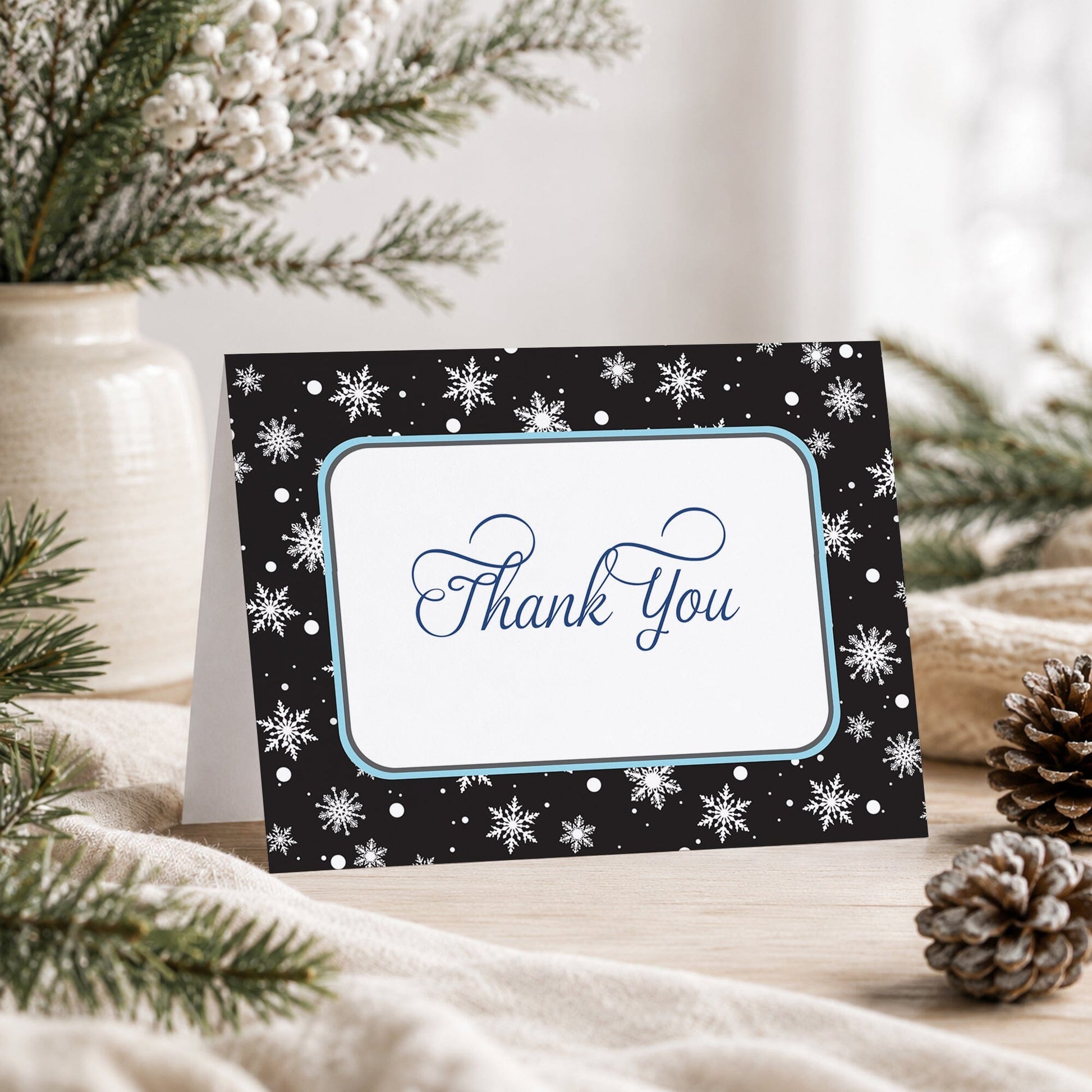 Midnight Snowflake Winter Thank You Card shown on a tabletop with a vase, winter greenery, and pine cones.