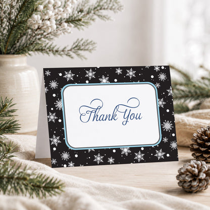 Midnight Snowflake Winter Thank You Card shown on a tabletop with a vase, winter greenery, and pine cones.