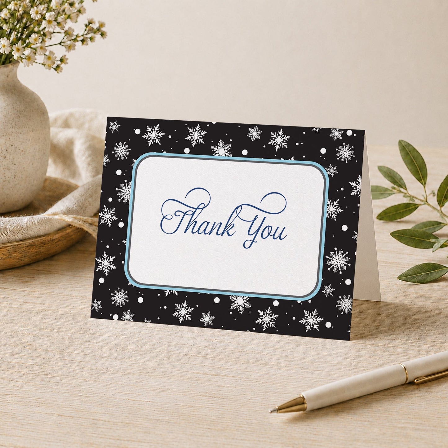 Midnight Snowflake Winter Thank You Card shown on a desk with a vase, plants, and a pen.