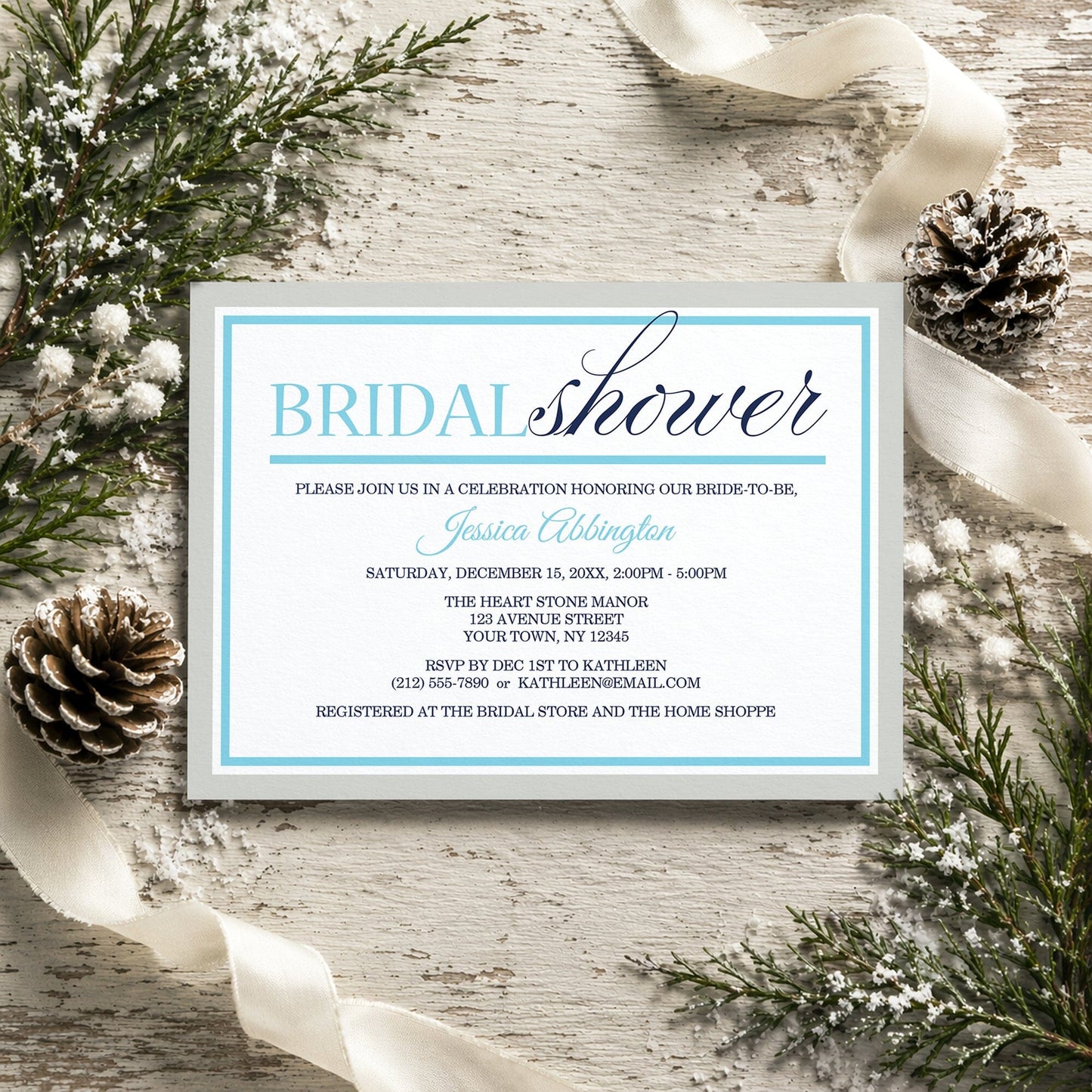 Modern Aqua Navy Gray Winter Bridal Shower Invitation on a rustic wooden surface with winter decorative elements like pine cones and ribbons.