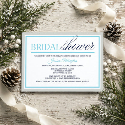 Modern Aqua Navy Gray Winter Bridal Shower Invitation on a rustic wooden surface with winter decorative elements like pine cones and ribbons.