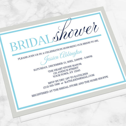 Modern Aqua Navy Gray Winter Bridal Shower Invitation shown at an angle on a marble surface with a white envelope.