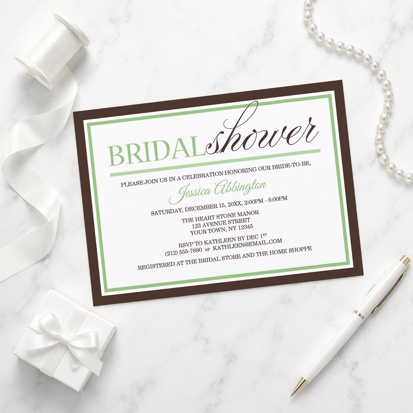 Modern Green and Brown Bridal Shower Invitation shown on a marble surface with a white gift box, pen, ribbon, and pearls.
