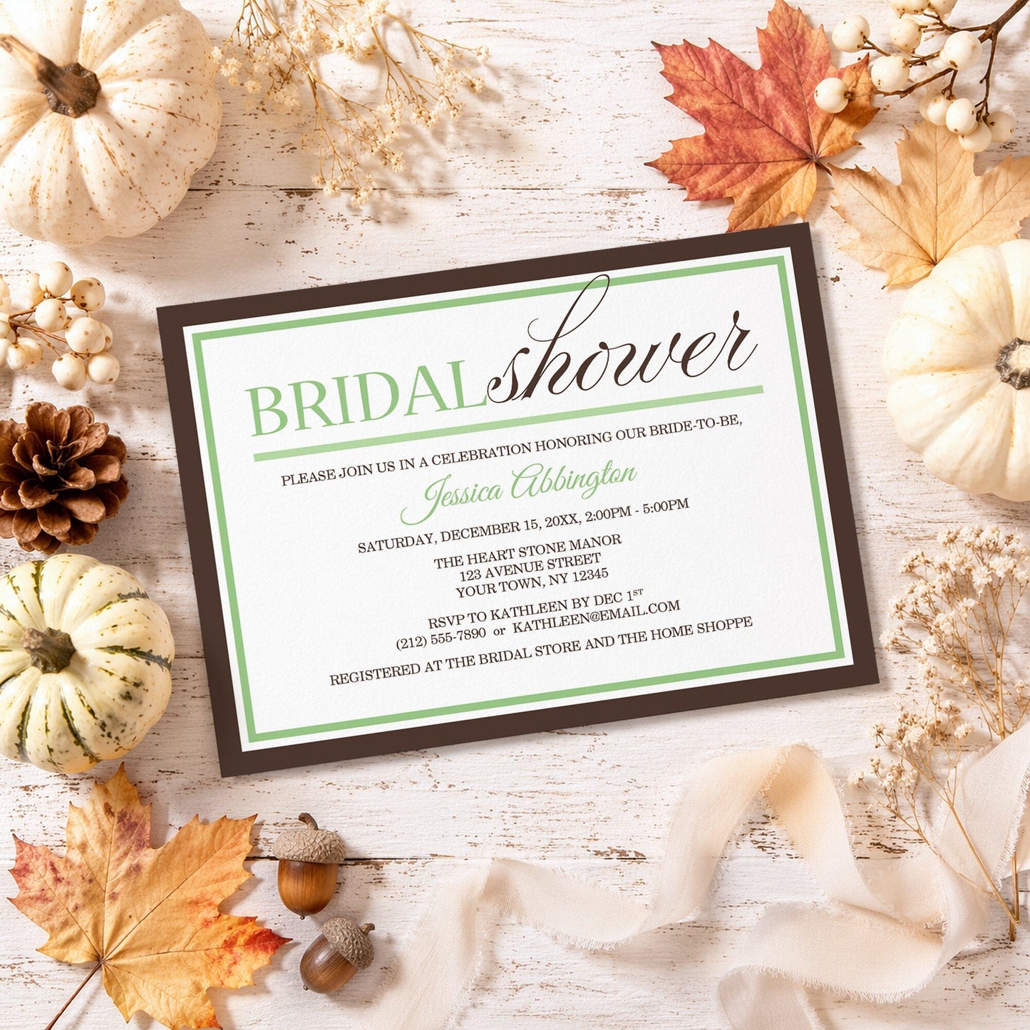Modern Green and Brown Bridal Shower Invitation shown on a rustic surface with fall leaves and autumn decor.