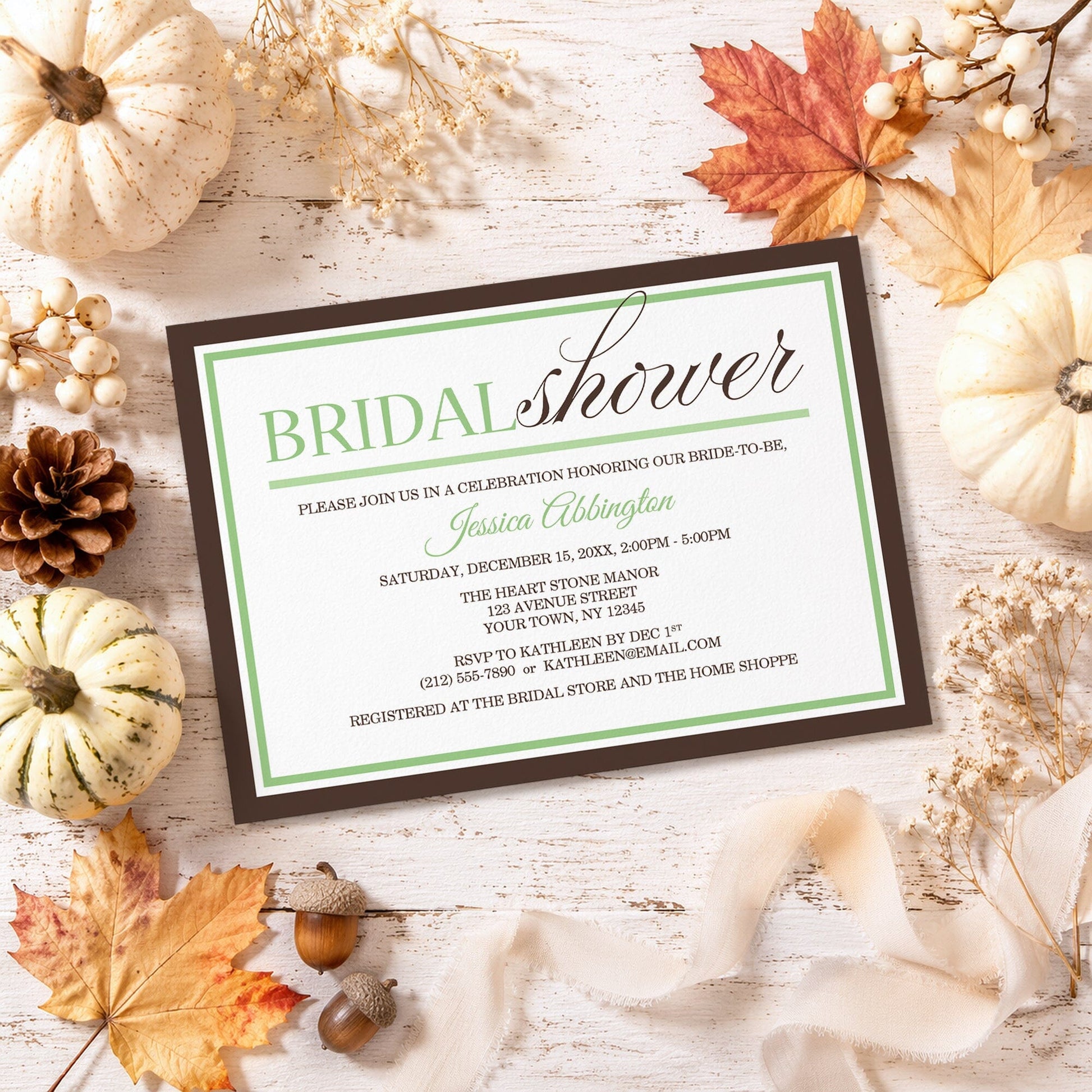 Modern Green and Brown Bridal Shower Invitation shown on a rustic surface with fall leaves and autumn decor.