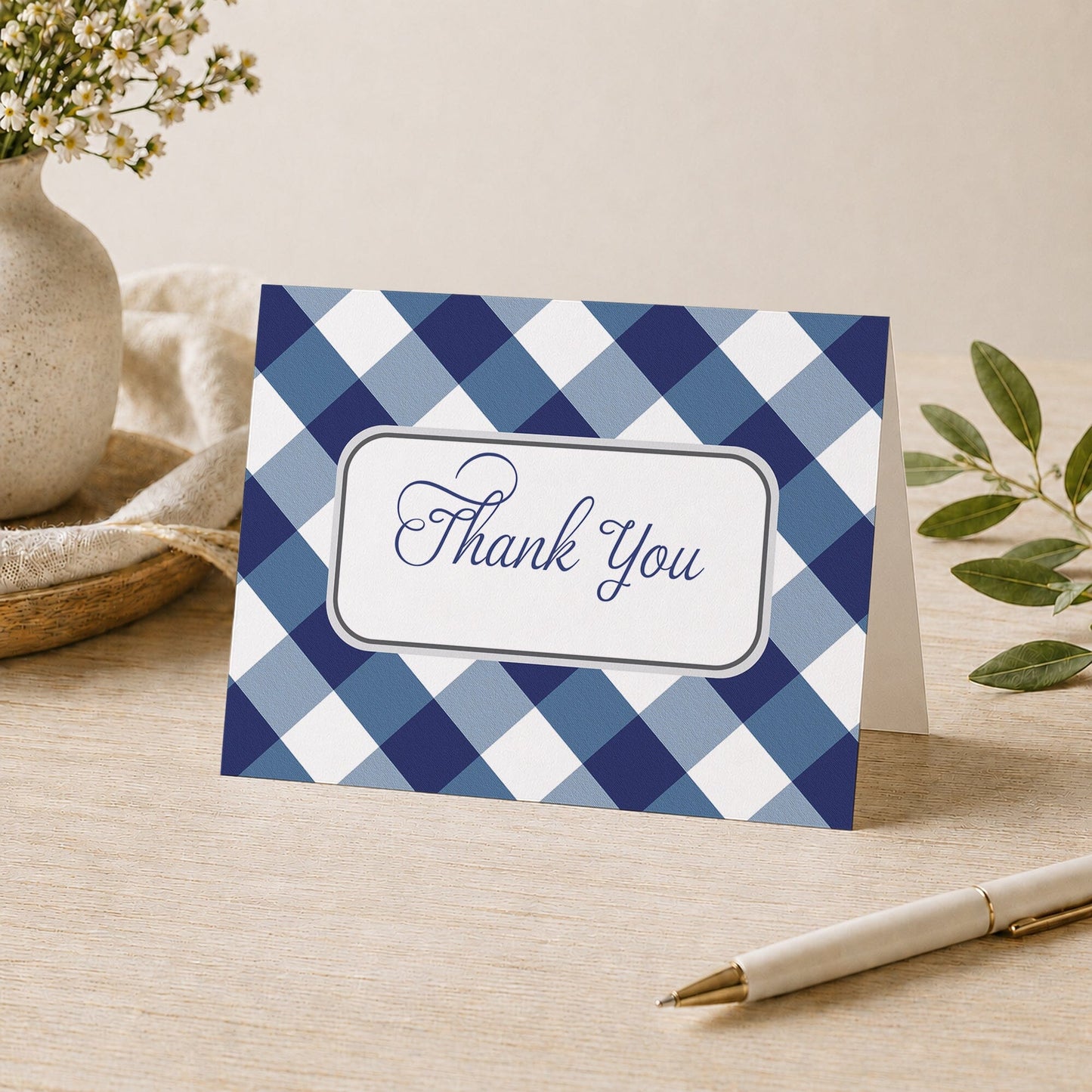 Navy Blue Gingham Thank You Card shown on a desk with a vase, plants, and a pen.