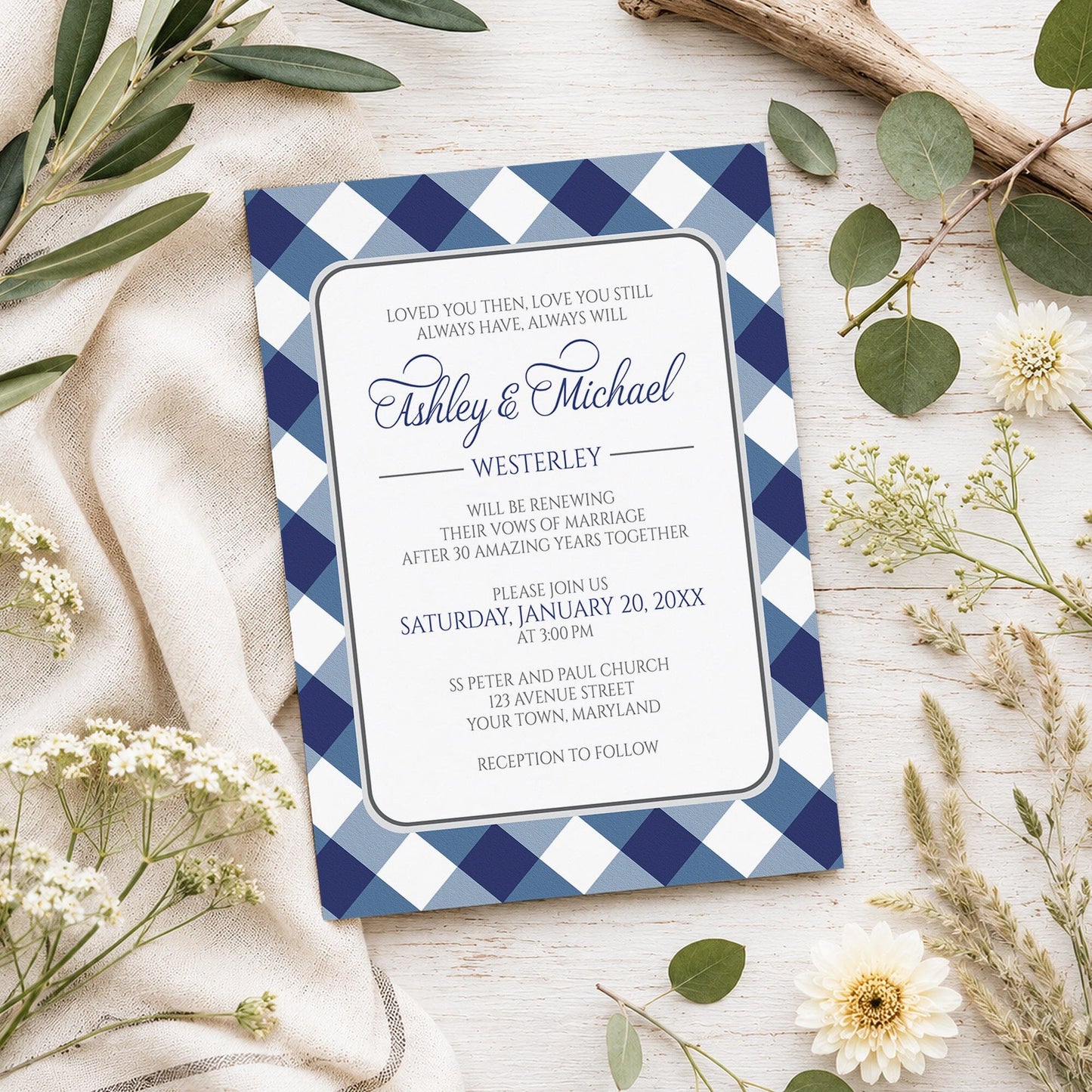 Navy Blue Gingham Vow Renewal Invitation shown on a light wooden surface with spring and summer plants.