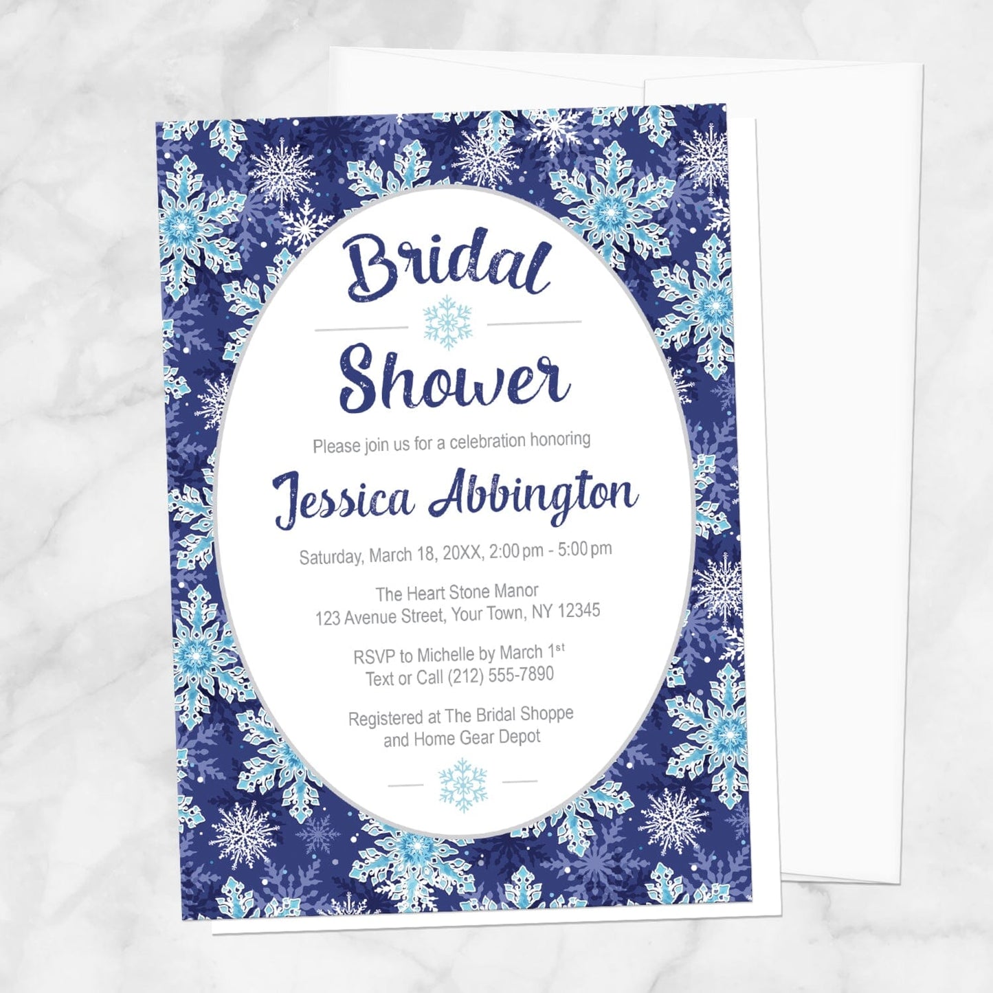 Navy Blue Snowflake Bridal Shower Invitation shown on a marble surface with a white envelope.