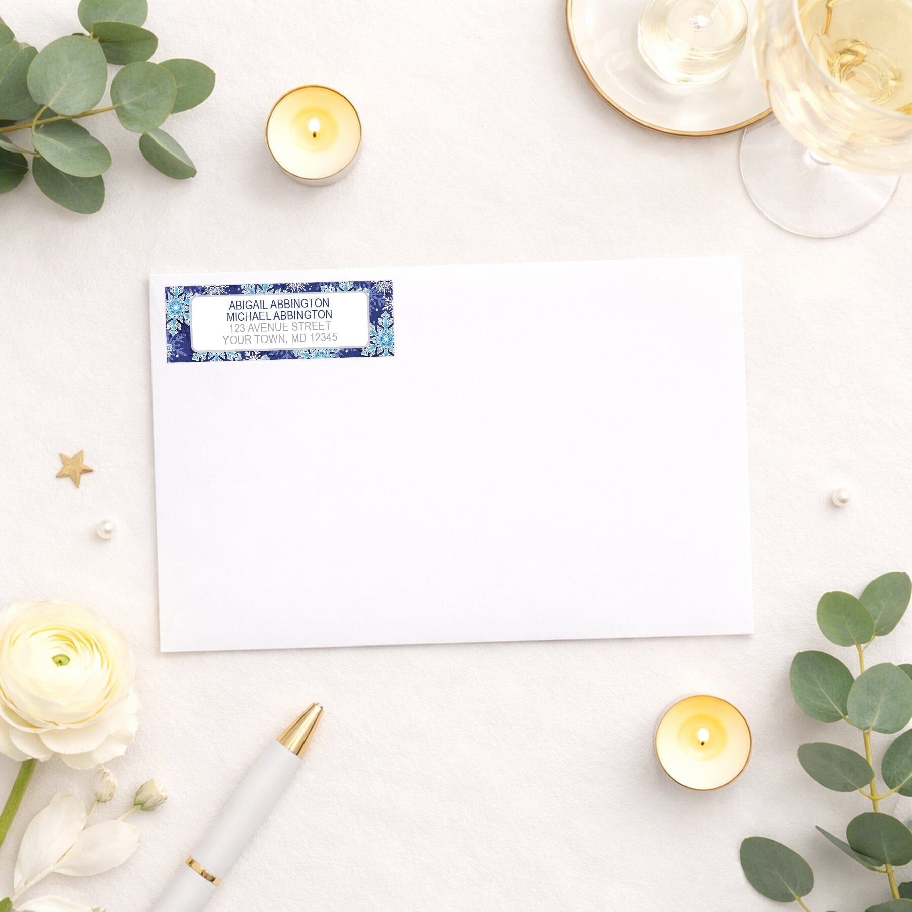 Navy Blue Snowflake Winter Return Address Label shown on a white envelope with wedding and shower supplies