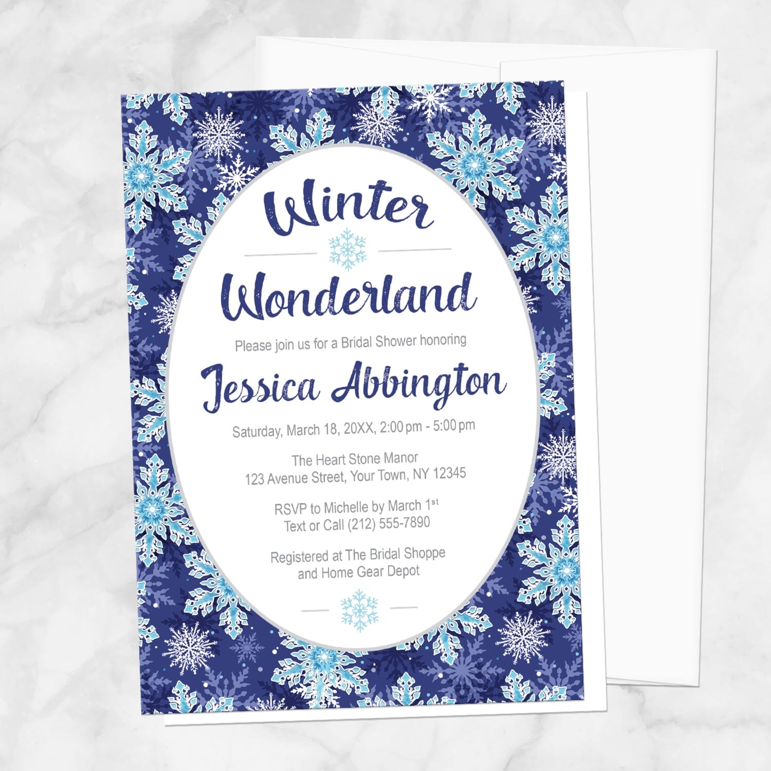 Winter Wonderland bridal shower invitation with a navy blue snowflake design shown on a marble surface with a white envelope.