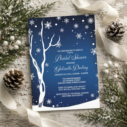 Navy Night Sky Snowflake Winter Bridal Shower Invitation shown on a rustic surface with winter greenery, pine cones, and ribbons.