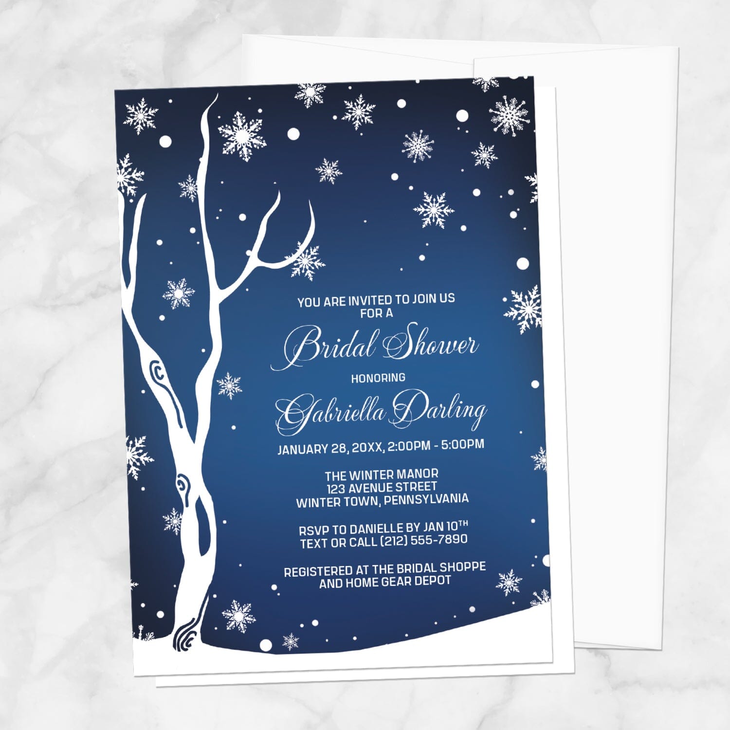 Navy Night Sky Snowflake Winter Bridal Shower Invitation shown on a marble surface with a white envelope.