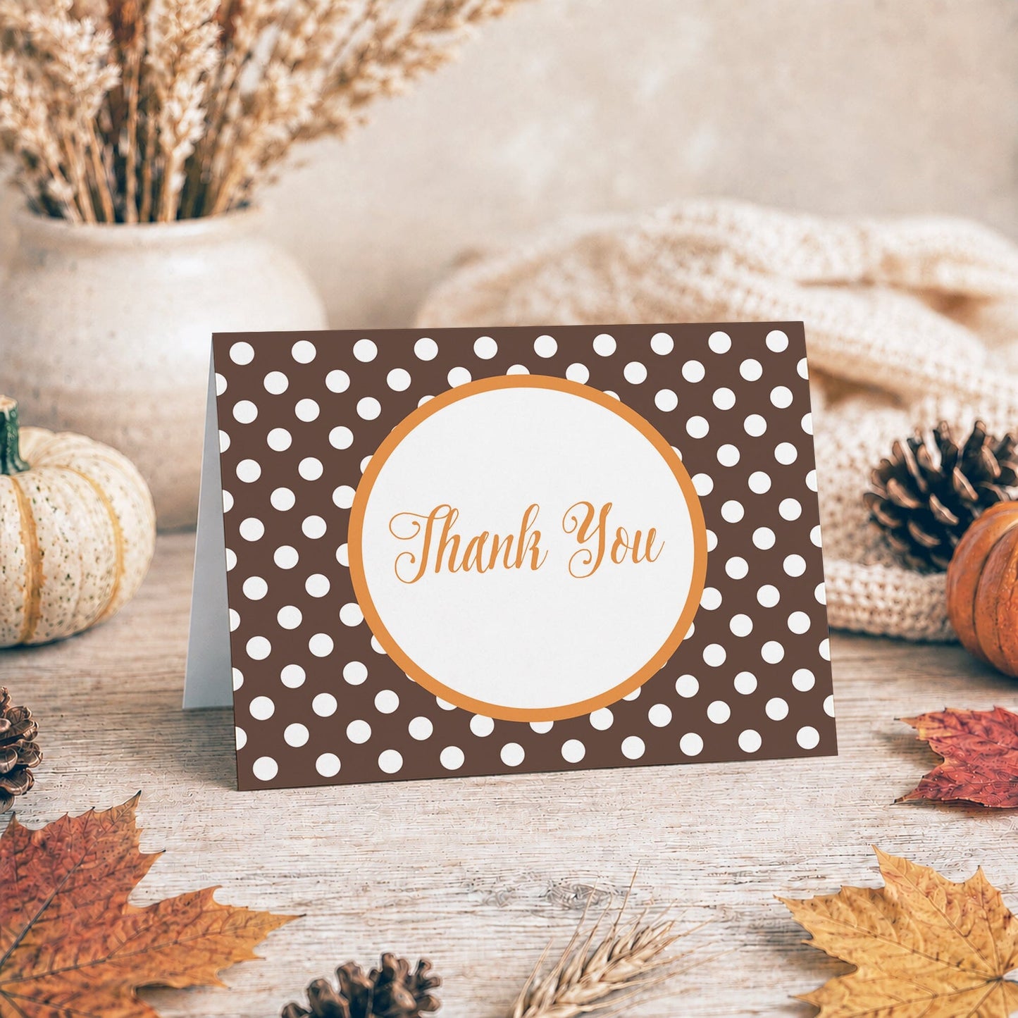 Orange Brown Polka Dot Thank You Card shown on a tabletop with a vase, fall leaves, and autumn decor.