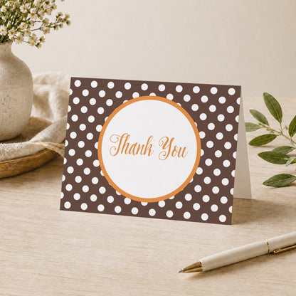 Orange Brown Polka Dot Thank You Card shown on a desk with a vase, plants, and a pen.