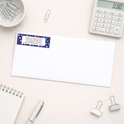 Patriotic Red White Blue Stars Address Label shown on a white envelope on a desk with office supplies.
