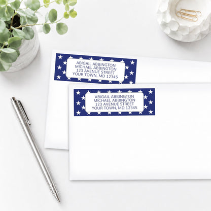 Patriotic White Stars on Blue Address Labels on white envelopes, on a white surface with a pen and plant.