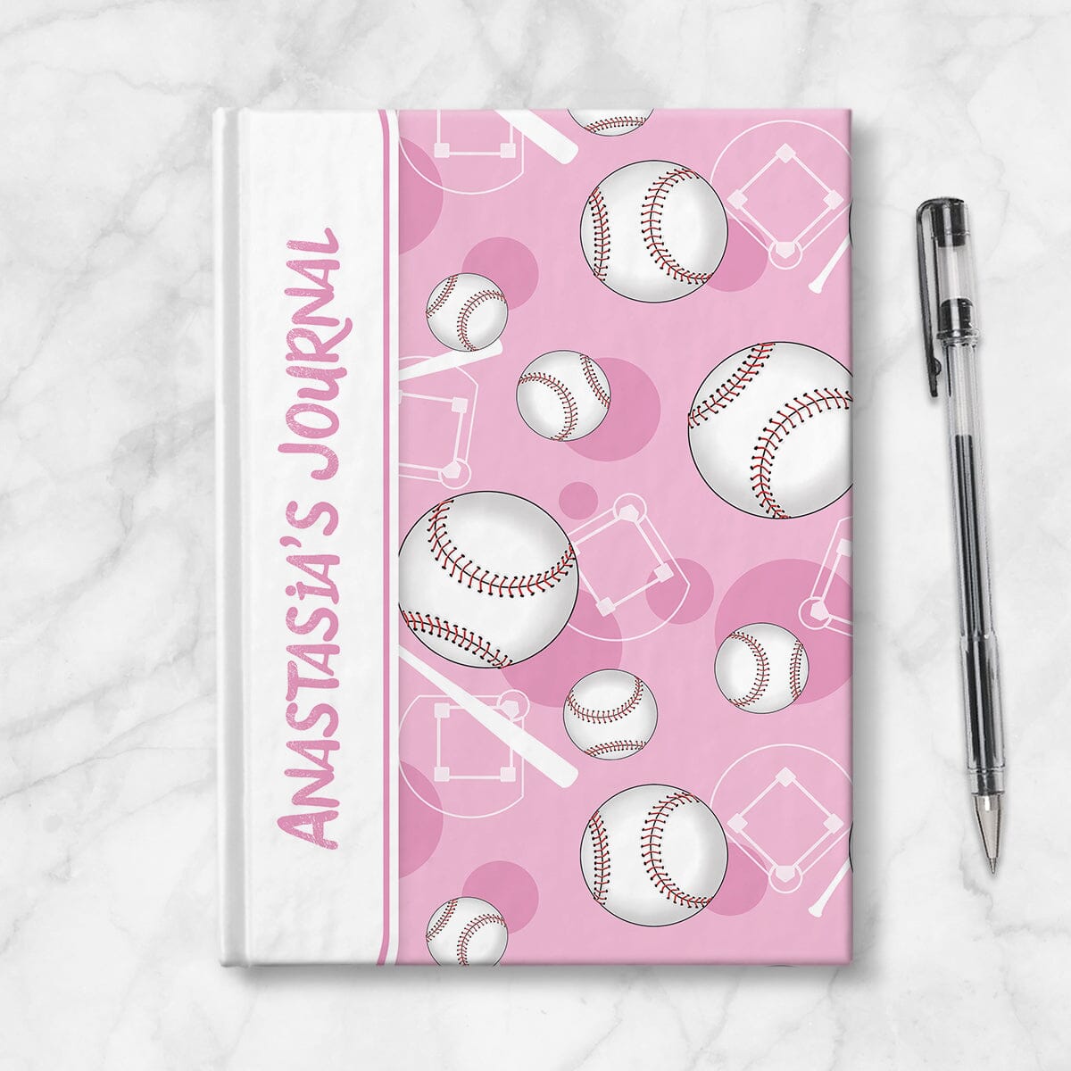 Personalized Pink Baseball Journal at Artistically Invited. Image shows the book on a countertop next to a pen.