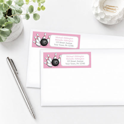 Pink Bowling Address Labels on white envelopes, shown on a white surface with a plant and a pen.