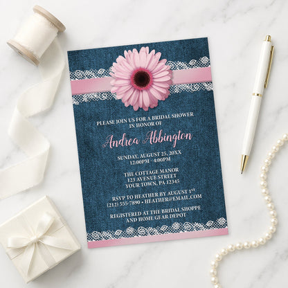 Pink Daisy Lace Rustic Denim Bridal Shower Invitation on a marble surface with a white gift box, ribbon, pen, and pearls.
