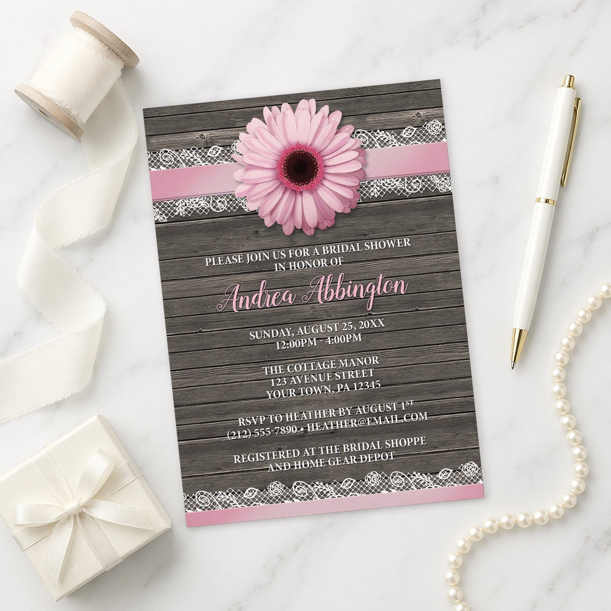Pink Daisy Lace Rustic Wood Bridal Shower Invitation shown on a marble surface with a white gift box, pen, ribbon, and pearls.