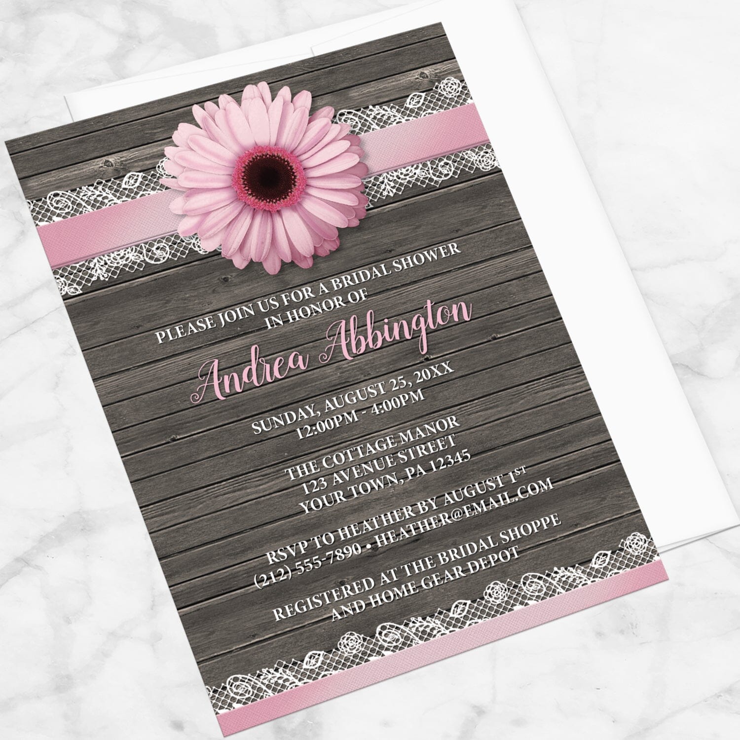 Pink Daisy Lace Rustic Wood Bridal Shower Invitation shown at an angle on a marble surface with a white envelope.
